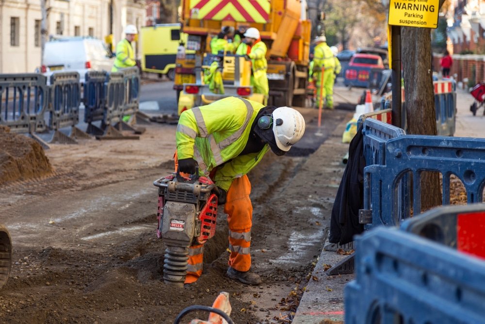A picture containing construction, outdoor, ground, blue-collar worker, land vehicle